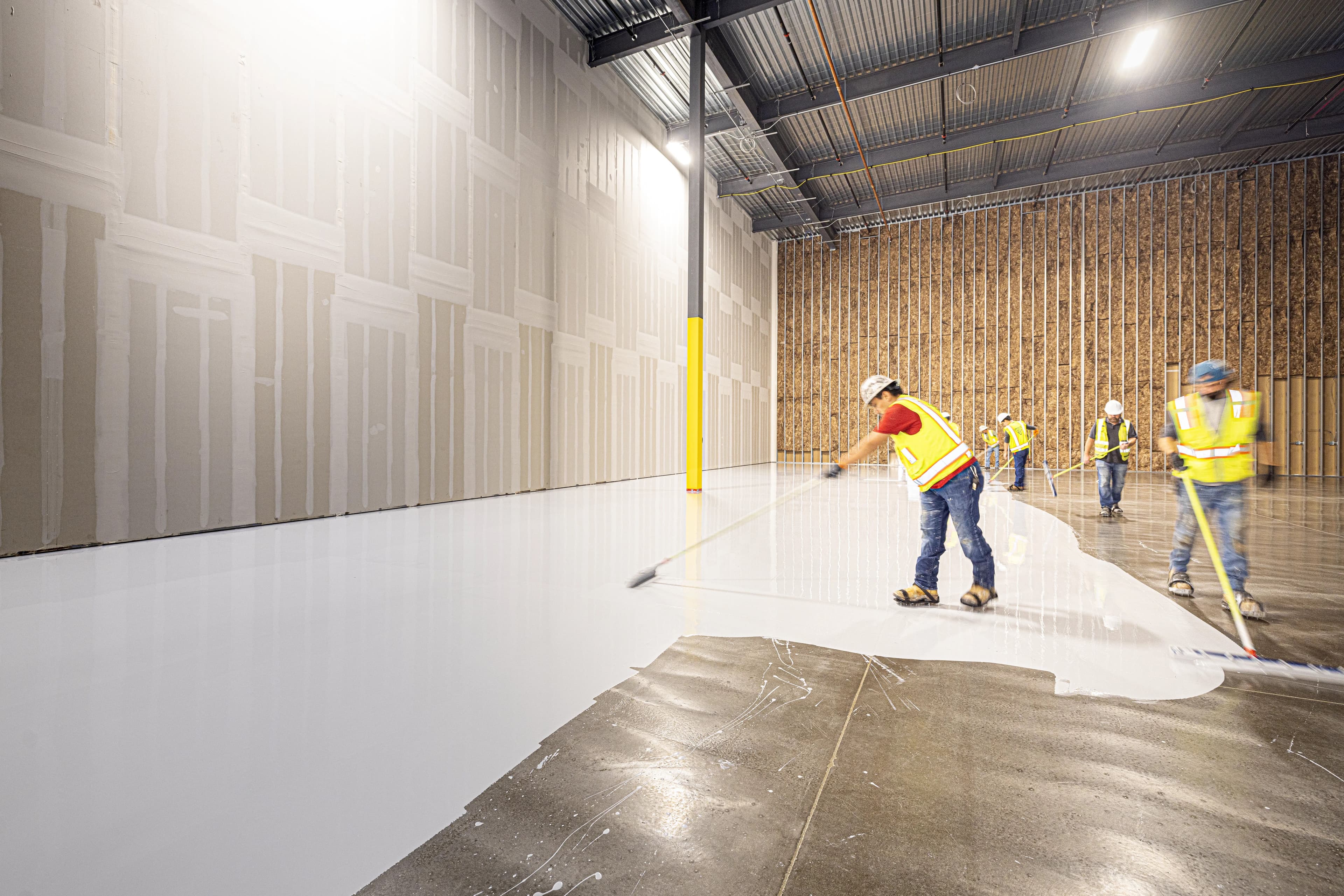 Crew applying a floor coating in a commercial facility